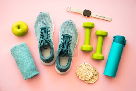 Photo for Healthy lifestyle concept. Sneakers, dumbbells, towel, diet food and bottle of water. Flat lay on pink. - Royalty Free Image
