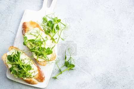 Photo for Open sandwich with cream cheese and micro greens. Healthy food, vegetarian dish. Flat lay on white with copy space. - Royalty Free Image