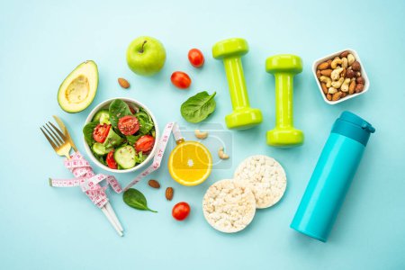 Photo for Diet food, healthy lifestyle and fitness background. Vegan salad, crispbread, fruits and dumbell. Flat lay with copy space. - Royalty Free Image