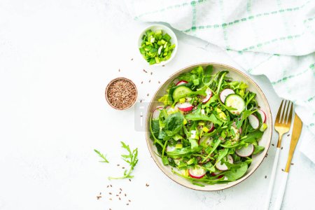 Téléchargez les photos : Salade verte aux épinards, roquette et radis à l'huile d'olive. Vue de dessus sur blanc. - en image libre de droit