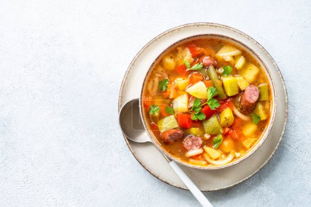 Minestrone Suppe, italienische Gemüsesuppe mit geräucherten Würstchen, Draufsicht.