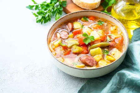 Foto de Sopa Minestrone, sopa de verduras italianas con salchichas ahumadas, Vista superior sobre mesa blanca. - Imagen libre de derechos