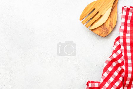 Foto de Utensilios de madera y mantel sobre mesa de cocina blanca. Fondo alimenticio con espacio de copia. - Imagen libre de derechos
