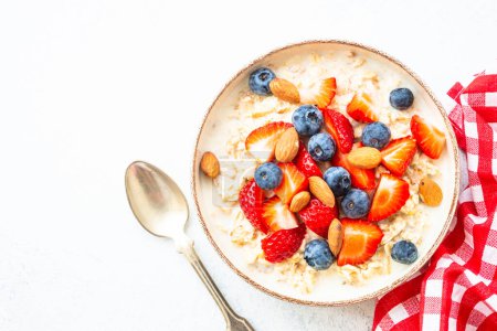 Photo for Oatmeal porrige with fresh berries and nuts. Healthy breakfast, top view. - Royalty Free Image