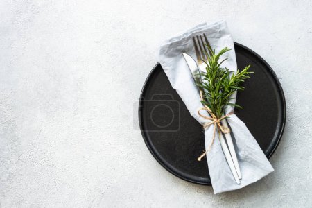 Téléchargez les photos : Assiette noire avec couverts sur table en pierre blanche. Espace de copie de vue supérieure. - en image libre de droit