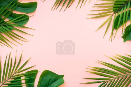 Summer flat lay background. Tropical leaves, palm leaves and monstera on pink background.