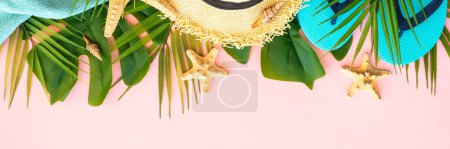 Photo for Summer holidays and travel concept. Palm leaves, sea shells, hat and flip flops on pink background. Long banner format. - Royalty Free Image