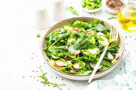 Téléchargez les photos : Salade verte aux épinards, roquette, radis à l'huile d'olive et graines. - en image libre de droit