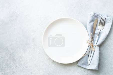 Photo for White plate and cutlery on stone table. Empty plate top view. - Royalty Free Image