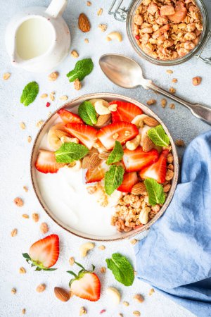 Photo for Yogurt with granola and strawberries on white. Healthy breakfast. Top view. - Royalty Free Image