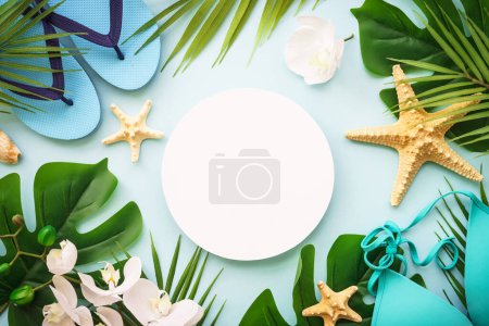 Photo for Palm leaves, flowers, flip flop and sea shells on blue. Summer composition with space for design. - Royalty Free Image
