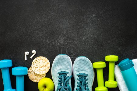 Photo for Workout and fitness concept. Sport equipment and diet food at black. Top view image with space for text. - Royalty Free Image