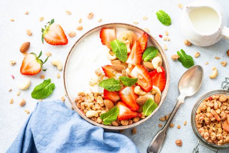 Foto de Yogur con granola y fresas sobre blanco. Snack o desayuno saludable, ensalada de frutas. Vista superior. - Imagen libre de derechos