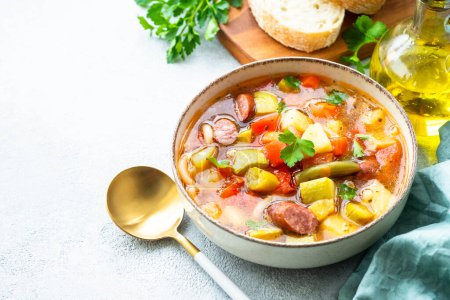 Photo for Minestrone soup, italian vegetable soup with smoked sausages, Top view on white table. - Royalty Free Image