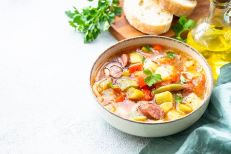 Foto de Sopa Minestrone, sopa de verduras italianas con salchichas ahumadas, Vista superior sobre mesa blanca. - Imagen libre de derechos