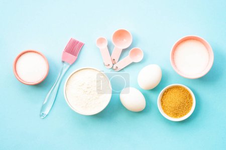 Photo for Baking background on blue. Ingredients for cooking baking, homemade recipe. Flour, sugar, eggs and utensils. Top view. - Royalty Free Image
