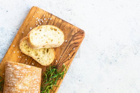 Photo for Italian ciabatta bread on wooden board. Top view with copy space on white table. - Royalty Free Image
