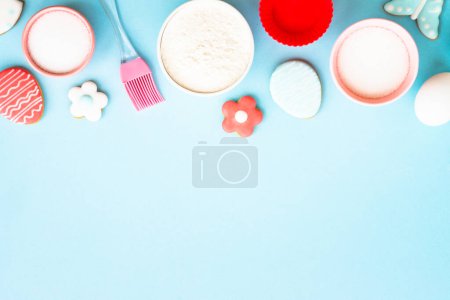 Photo for Easter baking, Flour, edds, sugar and gingerbread cookies. Top view on blue. - Royalty Free Image
