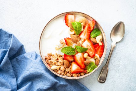 Téléchargez les photos : Yogourt au granola et fraises sur blanc. Snack sain ou petit déjeuner, salade de fruits. Vue du dessus. - en image libre de droit
