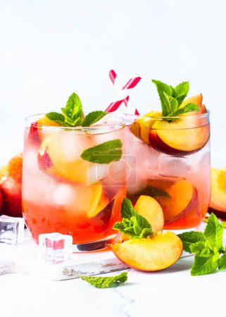 Photo for Peach cocktail, iced peach tea, fruit drink, summer beverage with fresh fruits and mint. - Royalty Free Image