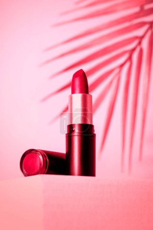 Téléchargez les photos : Rouge à lèvres sur fond rose. Image tonique. Maquillage, produits cosmétiques. - en image libre de droit