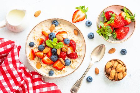 Photo for Oatmeal porrige with fresh berries and nuts. Healthy breakfast, top view. - Royalty Free Image