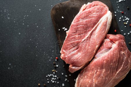 Photo for Raw meat steaks at dark background. Fresh meat. Top view with space for text. - Royalty Free Image