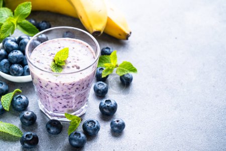 Photo for Blueberry banana smoothie or milkshake with fresh berries on stone table. - Royalty Free Image