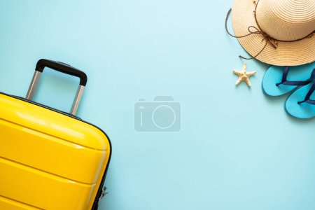 Foto de Maleta, sombrero y chanclas sobre fondo azul. Felices Fiestas, concepto de viaje. - Imagen libre de derechos
