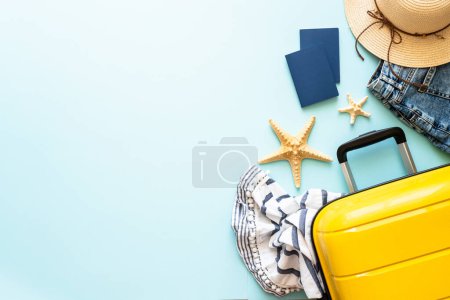 Téléchargez les photos : Valise, passeports, chapeau et tissu d'été sur fond bleu. Joyeuses fêtes, concept de voyage. Image de pose plate. - en image libre de droit
