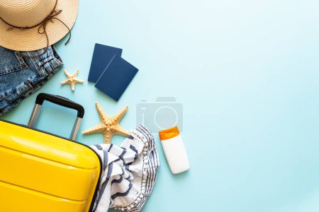Photo for Travel background, summer holidays. Suitcase, passports, hat and summer cloth on blue background. Flat lay image with copy space. - Royalty Free Image