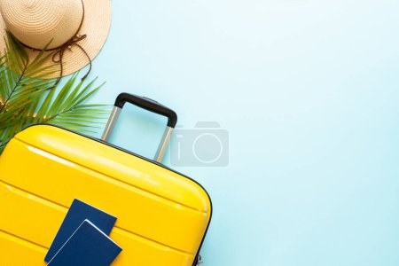 Photo for Suitcase, hat and flip flops on blue background. Happy Holidays, travel concept. Flat lay with space for text. - Royalty Free Image