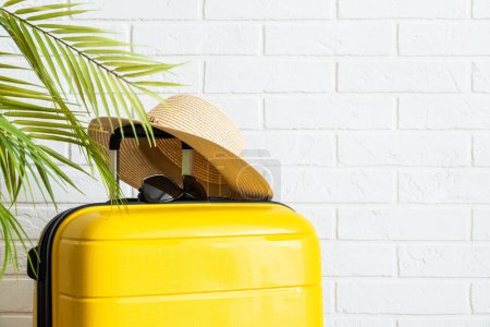 Photo for Summer holidays, traveling concept. Suitcase, hat and flip flops on white background. - Royalty Free Image