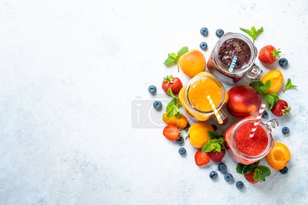 Foto de Set de batidos con frutas frescas y bayas de fondo blanco. Vista superior con espacio de copia. - Imagen libre de derechos