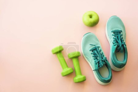 Foto de Equipo de fitness sobre fondo rosa, imagen plana. Zapatillas, mancuernas, toalla y botella de agua. Concepto de entrenamiento, entrenamiento y fitness. - Imagen libre de derechos
