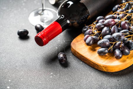 Photo for Red Wine at black background. Glass of wine, bottle and crape. - Royalty Free Image