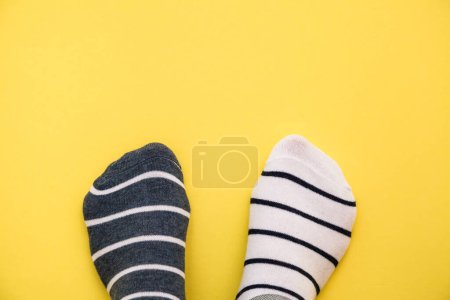Téléchargez les photos : Bizarre concept de journée chaussettes. Jambes en chaussettes différentes sur fond bleu. Vue du dessus. - en image libre de droit