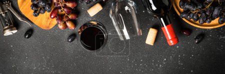 Téléchargez les photos : Vin rouge à fond noir. Verre de vin, bouteille et craps. Format long. - en image libre de droit