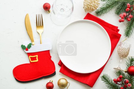 Foto de Mesa de Navidad. Placa blanca, cubiertos, decoraciones rojas y doradas. Vista superior en mesa blanca. - Imagen libre de derechos
