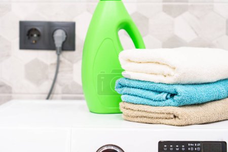 Téléchargez les photos : Une pile de serviettes de bain et de détergent. Serviettes propres dans la buanderie ou la salle de bain. - en image libre de droit