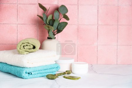 Téléchargez les photos : Serviettes propres et produits cosmétiques dans la salle de bain. - en image libre de droit