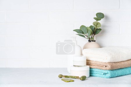 Foto de Productos cosméticos y toallas limpias en el baño. Tratamiento de spa y productos de belleza. - Imagen libre de derechos