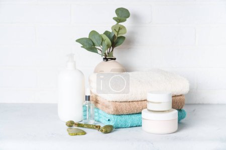 Téléchargez les photos : Produits de beauté, cosmétiques naturels et serviettes propres dans la salle de bain. Soins spa et produits de beauté. - en image libre de droit
