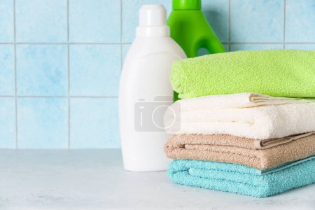 Photo for Clean towels and detergent in the laundry or bathroom against blue wall. - Royalty Free Image