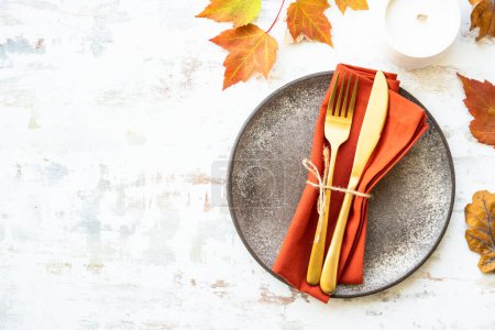 Photo for Craft plate, cutlery and autumn decorations on white background. Flat lay with copy space. - Royalty Free Image
