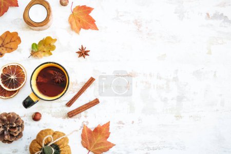 Photo for Fall background. Cozy autumn on white. Cup of spicy tea, autumn leaves, spices and decor. Flat lay with copy space. - Royalty Free Image