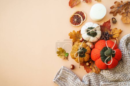 Photo for Autumn flat lay background. Homemade knitted pumpkins, sweater, leaves and home decor on color background. - Royalty Free Image