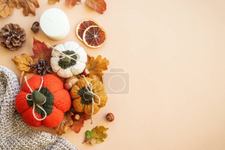 Photo for Autumn decorations. Knitted pumpkins, leaves, candle and others on color background. Home decor. - Royalty Free Image