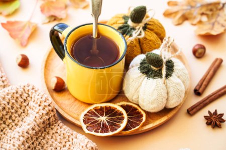 Photo for Cup of tea, spices, dry leaves, and knitted autumn decorations. Cozy autumn composition. - Royalty Free Image