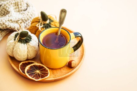 Photo for Cup of tea, spices, dry leaves, and knitted autumn decorations. Cozy autumn composition. - Royalty Free Image